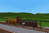 Two loaded European small open wagons, one with a brakeman's hut, wait to be picked up.
