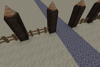 A gravel path running between two spike-topped logs